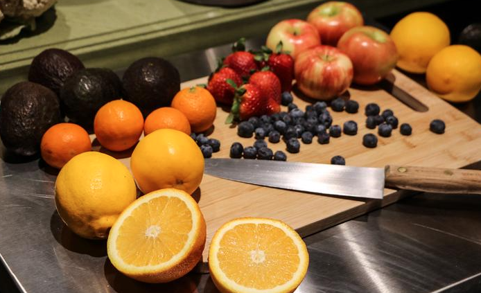 Some fruits and a knife on a cutting board