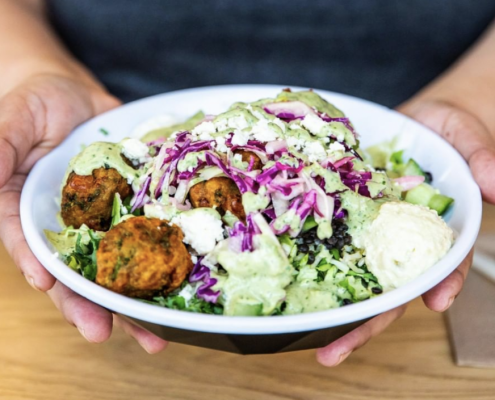 person holding a falafel salad