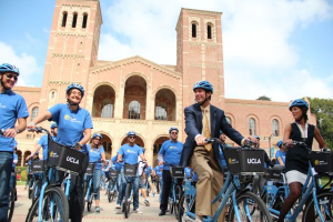 A group of people biking on campus using the ucla bikes