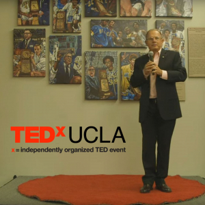 TedxUCLA - a man stands on a red carpet with a microphone in his hand.