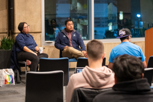 A group of people listen to a presenter.