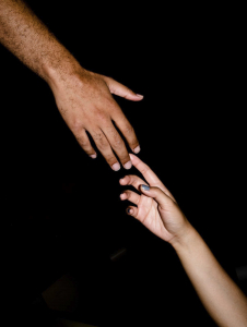 Two hands touch one another gently.