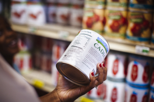 A person holds up a can of food.