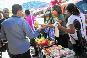 Women sell fruit to a man on the streets of LA.