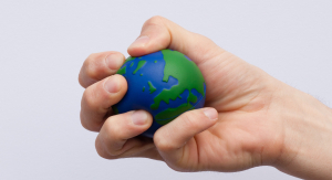 An individual squeezes an Earth shaped/designed stress ball.