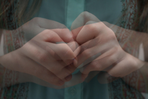 An overlayed picture of a person holding their hands together anxiously.