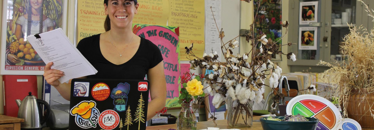 A woman smiles while standing behind a counter.