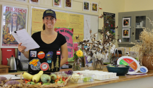 A woman smiles while standing behind a counter.