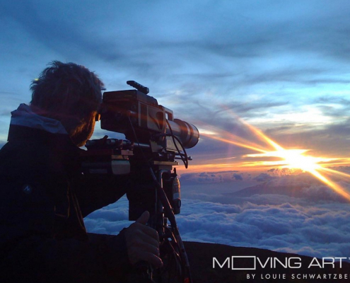 A filmmaker takes a video of a beautiful sunset over the clouds.