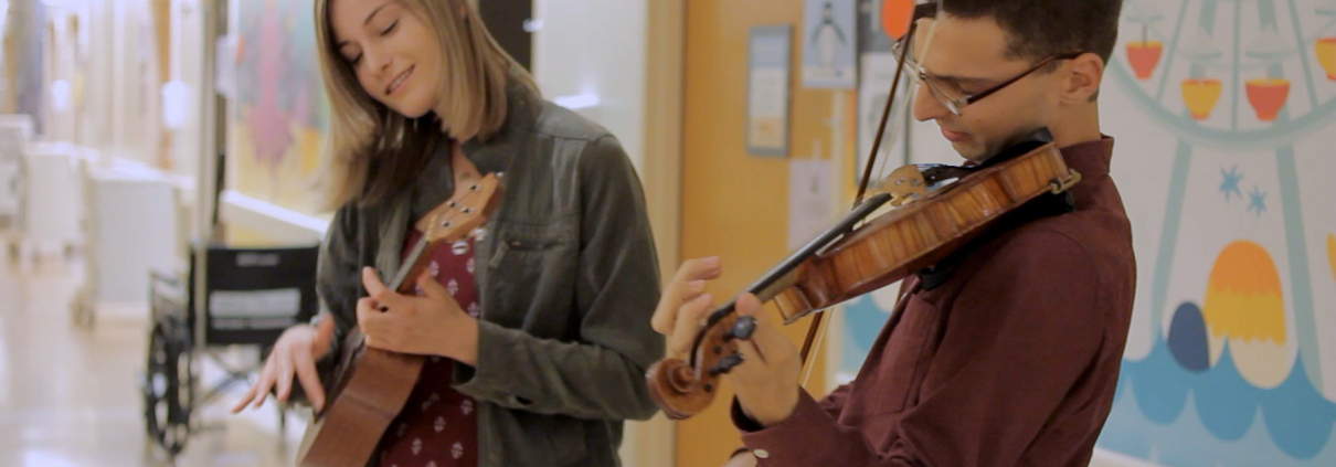 2 students play instruments in the UCLA children's hospital.