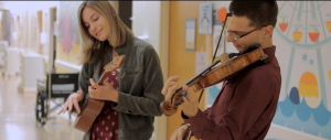 2 students play instruments in the UCLA children's hospital.