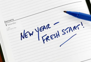 New Year - Fresh start is written on a notebook page.