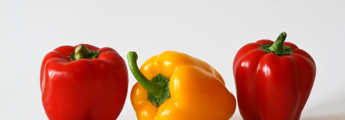 3 bell peppers are placed on a table.