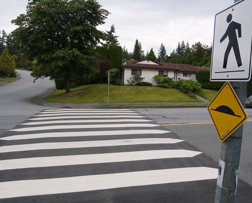 A crosswalk with a sign next to it.