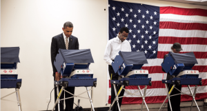 Barack Obama and other individuals vote at the in-person voting machines.