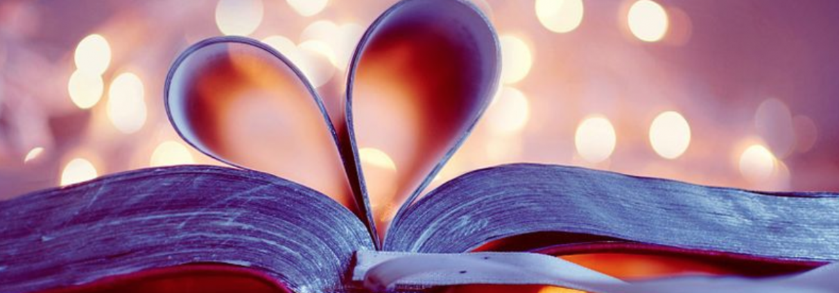 A close-up shot of an open book with the pages turned into a heart.