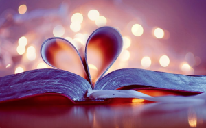A close-up shot of an open book with the pages turned into a heart.