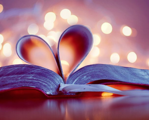 A close-up shot of an open book with the pages turned into a heart.
