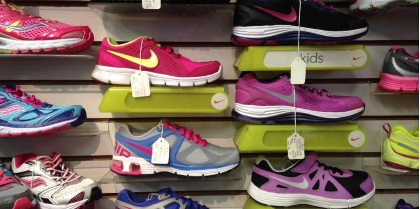 A large rack of various colored and branded running or athletic shoes.